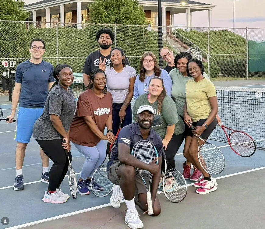 Coach Jordan Dingle with players after a training session at Newman Tennis Center